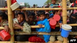 Rohingya refugees wait for food aid at Thankhali refugee camp in Bangladesh's Ukhia district on January 12, 2018.