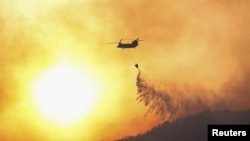 A Japanese Self-Defense Force helicopter conducts firefighting operations on a wildfire site in Ofunato, Iwate Prefecture, northeastern Japan, March 4, 2025, in this photo taken by Kyodo. (Kyodo/via Reuters) 