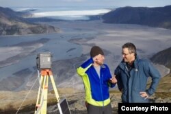 UCLA geography graduate student Lincoln Pitcher, left, and UCLA geography professor Laurence C. Smith overlook the Isortoq River, where meltwater leaves the Greenland ice sheet to flow to the ocean seen in the distance. (UCLA/Lawrence C. Smith)