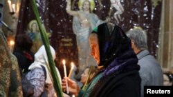 A Christian worshipper takes part in a Palm Sunday ceremony in the Church of the Holy Sepulchre in Jerusalem's Old City, April 9, 2017. 