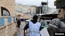 Seorang staf UNRWA tampak mendorong troli di area kamp pengungsi AIDA di Bethlehem, wilayah Tepi Barat yang diduduki, pada 5 Februari 2024. (Foto: Reuters/Mussa Qawasma)