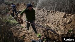 Fighters from the Free Syrian Army's Al Majd Brigades dig a trench in the rebel-held besieged area of al-Marj in the Eastern Ghouta of Damascus, Syria, Feb. 18, 2017. 