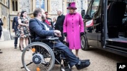 FILE - Britain's Queen Elizabeth II talks to Edward Todino as she presents him with his new 'Motability' vehicle during a ceremony at Windsor Castle, in Windsor, England, April 25, 2017. 