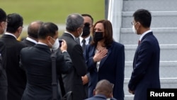 Vice-presidente americana Kamala Harris recebida pelo ministro dos Negócios Estrangeiros de Singapura, Vivian Balakrishnan na base Aérea Paya Lebar em Singapura, 22 de Agosto, 2021. 