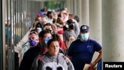 FILE - Job seekers line up outside a Career Center in Frankfort, Kentucky, June 18, 2020. 