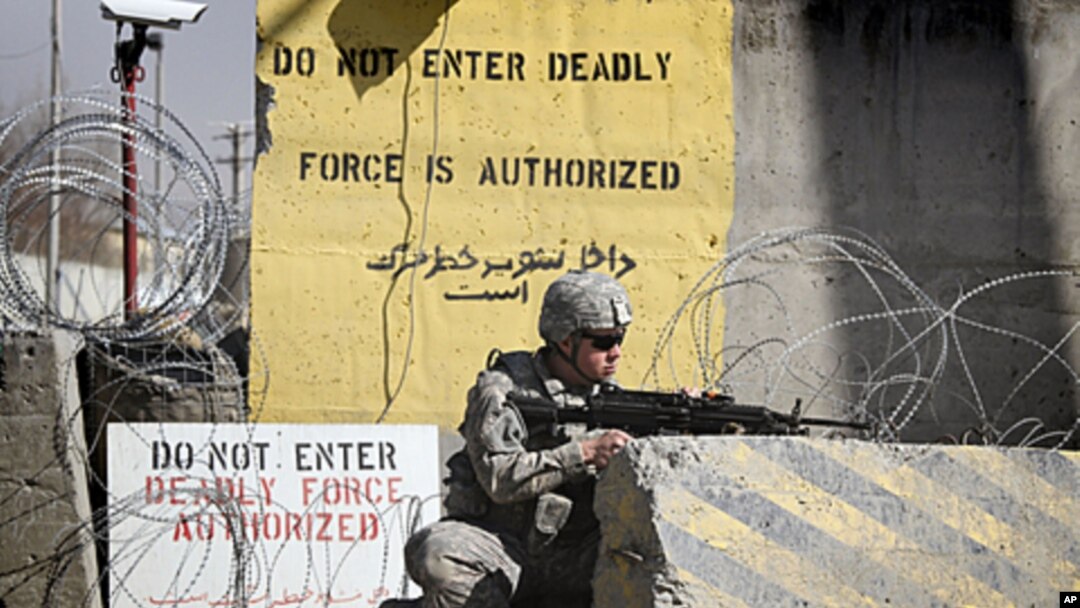 A US soldier controls the area outside the gate of a US base, April 2, 2011 (file photos).