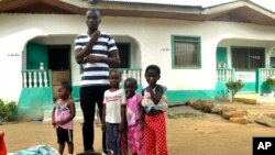 James Harris, le veuf de Salome Karwah, et ses enfants posent pour des photographies en dehors de sa maison à Monrovia, Liberia, 2 mars 2017.