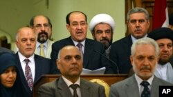 Manm palman irakyen an ap tande Premye Minis Nouri al-Maliki (nan mitan) pandan li tap li yon mesaj kote li anonse demisyon n aprè 8 tan li pase kòm chèf gouvènman an (Bagdad, 14 out 2014).