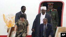 ARCHIVES - Le président soudanais Omar el-Béchir, turban blanc sur la tête, descend d'un avion.