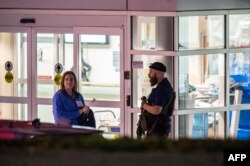 Seorang petugas penegak keamanan berjaga di pintu masuk ambulans di rumah sakit Central Maine Medical Center di Lewiston, Maine, Kamis dini hari, 26 Oktober 2023. (Foto: Joseph Prezioso/AFP)