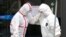 Medical workers wearing protective gears comfort each other outside a hospital in Daegu, South Korea, Feb. 28, 2020.
