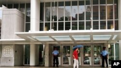 Petugas keamanan berjaga di depan pintu masuk kantor pusat Bank Dunia di Washington, 1 Agustus 2014.