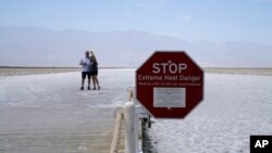 A sign warns of extreme heat danger at Badwater Basin, Aug. 17, 2020, in Death Valley National Park, California. 