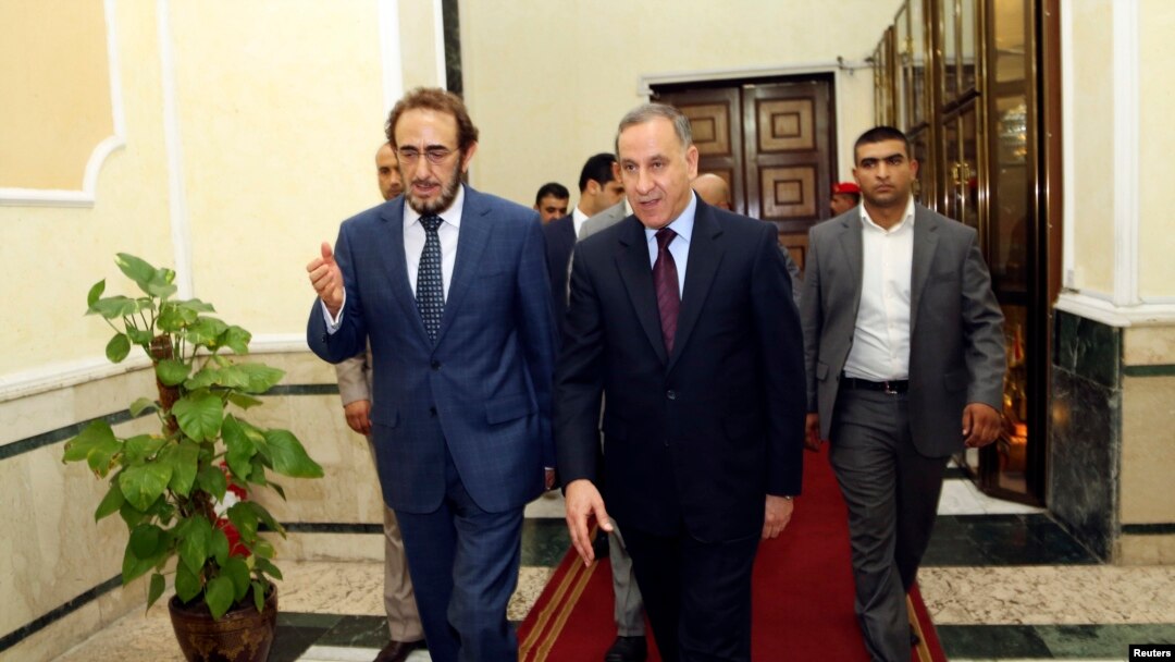 Iraq's new Defense Minister Khaled al-Obeidi (C) walks with acting Defense Minister Saadoun al-Dulaimi (L) at the Defense Ministry in Baghdad, Oct. 19, 2014.