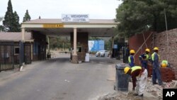 Builders work outside the main entrance of the Weskoppies Psychiatric Hospital, in Pretoria, South Africa, May 20, 2014. 