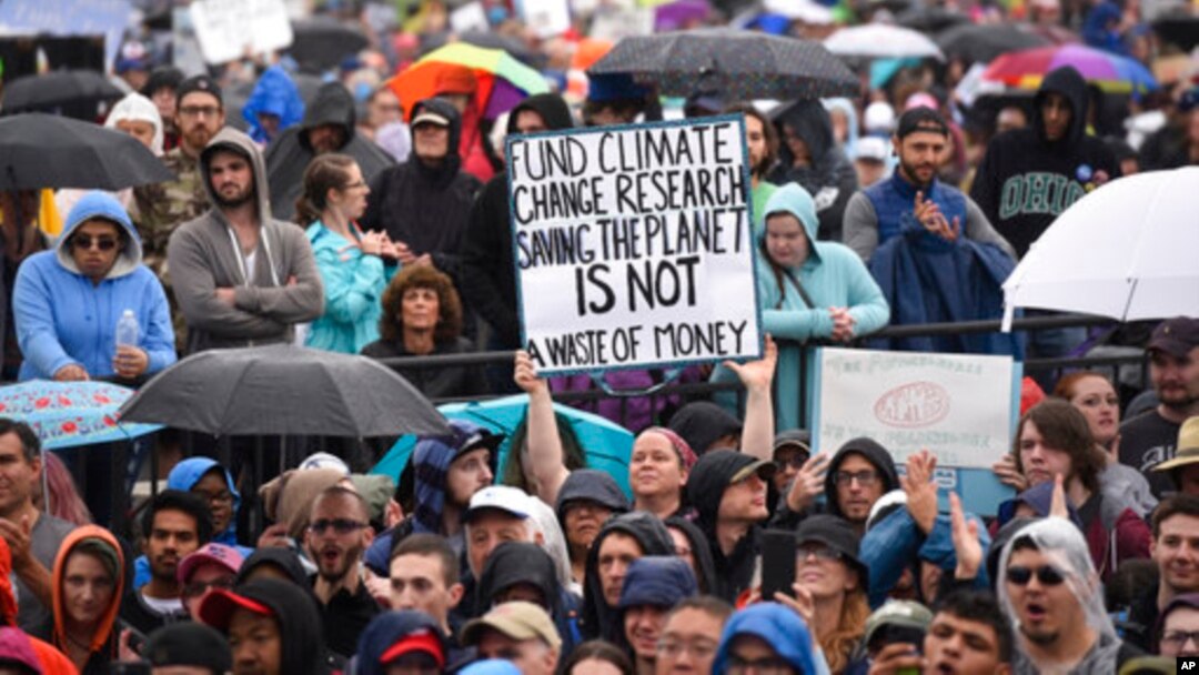 A person hold up a sign that reads "Fund Climate Change Research Saving The Planet Is Not a Waste of Money" during the March for Science in Washington, D.C., April 22, 2017.