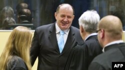 Former Bosnian Serb interior minister Mico Stanisic (C) greets his lawyers as he arrives on March 27, 2013 to attend the Trial Chamber Judgement at the International Criminal Tribunal for the former Yugoslavia in The Hague, The Netherlands.