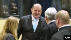 2013年3月27日，前波黑內政部長斯塔尼希奇（中）在參加庭審前會見律師。 （資料照片）