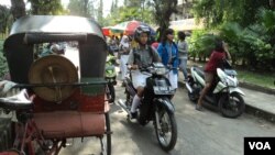 Pelajar bermotor melintas di jalur lambat Jl. Adisucipto, Solo. (VOA/Yudha Satriawan)