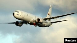 A P-8A Poseidon surveillance plane conducts flyovers above the Enterprise Carrier Strike Group on February 3, 2012 in this handout photo courtesy of the U.S. Navy.