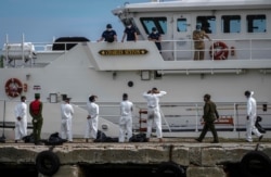 FILE - Cuban deportees wait to be quarantined at a COVID control center, after disembarking from Coast Guard cutter Charles Sexton to be handed over to the Cuban authorities at Orozco Bay in Artemisa, Cuba, June 29, 2021.