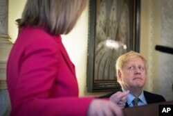 Britain's Prime Minister Boris Johnson listens to British politician Liz Truss during a panel event and reception to mark International Women's Day at Downing Street in Westminster, London, March 5, 2020.