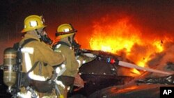 Firefighters battle an arson car fire in Los Angeles , Jan. 2, 2012.