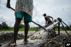 Small-scale miners look for gold at the Atrato River in Dona Josefa, Colombia, Sept. 26, 2024.