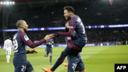 L’attaquant brésilien du PSG, Neymar (à droite), son coéquipier français Layvin Kurzawa (centre en bas) et Kylian Mbappe jubilent après un but lors du match du championnat français contre et Marseille (OM) au Parc des Princes, Paris, 25 février 2018.