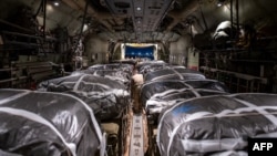 In this image obtained from the U.S. Department of Defense, humanitarian aid pallets rigged with parachutes for an airdrop over Gaza aboard a C-130J Super Hercules are loaded and prepared for takeoff at an undisclosed location in Southwest Asia, March 1, 2024.