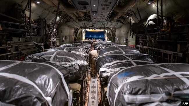 In this image obtained from the U.S. Department of Defense, humanitarian aid pallets rigged with parachutes for an airdrop over Gaza aboard a C-130J Super Hercules are loaded and prepared for takeoff at an undisclosed location in Southwest Asia, March 1, 2024.