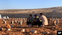 People pray at the graves of the flash flood victims in Derna, Libya, Friday, Sept. 15, 2023. 