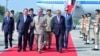 This handout photograph taken and released by Pakistan's Prime Minister Office on October 14, 2024 shows China's Premier Li Qiang, center left, speaking with Pakistan's Prime Minister Shehbaz Sharif upon his arrival at the Chaklala military air base inIslamabad.