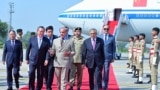 This handout photograph taken and released by Pakistan's Prime Minister Office on October 14, 2024 shows China's Premier Li Qiang (C, left) speaking with Pakistan's Prime Minister Shehbaz Sharif (C) upon his arrival at the Chaklala military air base in Is