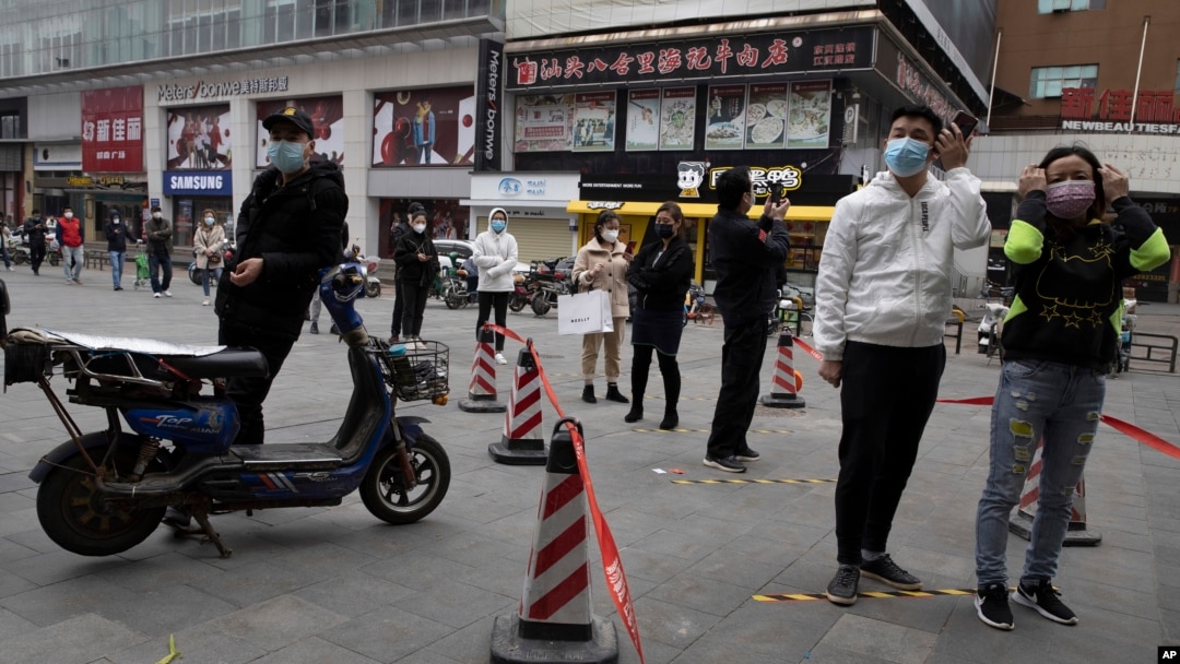 Warga dengan mengenakan masker antri untuk memasuki supermarket di Wuhan, Hubei, China, Jumat (3/4). Kota Wuhan adalah kota di mana kasus pertama Covid-19 diketahui. 