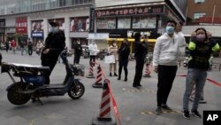 Warga dengan mengenakan masker antri untuk memasuki supermarket di Wuhan, Hubei, China, Jumat (3/4). Kota Wuhan adalah kota di mana kasus pertama Covid-19 diketahui. 