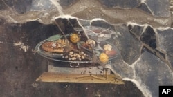 نقاشی دیواری ۲ هزار ساله که در سایت باستان‌شناسی پمپئی کشف شده یک سینی غذا با جام شراب را به تصویر کشیده است.