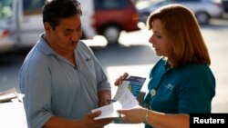 Una promotora de salud habla con un hombre sobre el Obamacare en Los Ángeles.