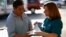 Una promotora de salud habla con un hombre sobre el Obamacare en Los Ángeles.