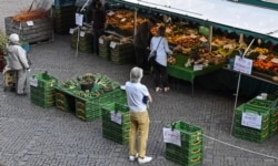 People keep distance due to the coronavirus at a market in Aachen, Germany, April 9, 2020.