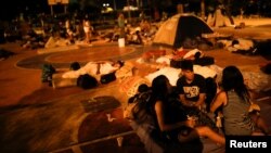 People prepare to sleep on the floor of a sports center, where a community of homeless Venezuelan migrants stays, in Cucuta, Colombia, Jan. 24, 2018. 