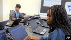 FILE - In this March 13, 2019, photo, Bennett High School students work on laptops in a school computer lab in Buffalo, N.Y.