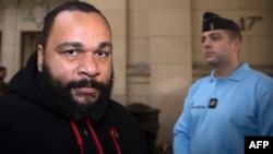 French controversial humorist Dieudonne Mbala Mbala arrives for a trial at the Paris courthouse on December 13, 2013 on the charges of defamation, insults, incentive to hate and discrimination.