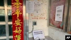 A registration book for residents who have recently returned from other provinces is displayed at the entrance to a neighborhood in Beijing, Jan. 31, 2020.
