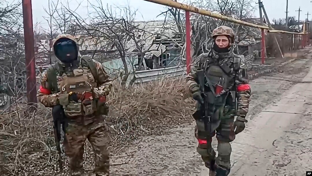 Dua tentara unit teknik militer Rusia berjalan saat sedang bertugas untuk membersihkan ranjau di Kota Avdiivka, Ukraina timur. (Foto: via AP)