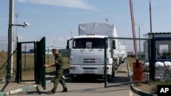 Vojnik na rusko-ukrajinskoj granici otvara kapiju za jedan od kamiona iz humanitarnog kovoja