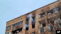 Smoke pours from an apartment building after a suspected gas explosion, in Khimki, outside Moscow, Russia, March 19, 2021.