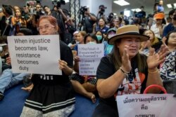 Supporters of Thailand's Future Forward Party display placards denouncing a decision by the country's Constitutional Court to dissolve the party, in Bangkok, Thailand, Feb. 21, 2020.