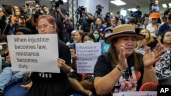 Supporters of Thailand's Future Forward Party display placards denouncing a decision by the country's Constitutional Court to dissolve the party, in Bangkok, Thailand, Feb. 21, 2020.