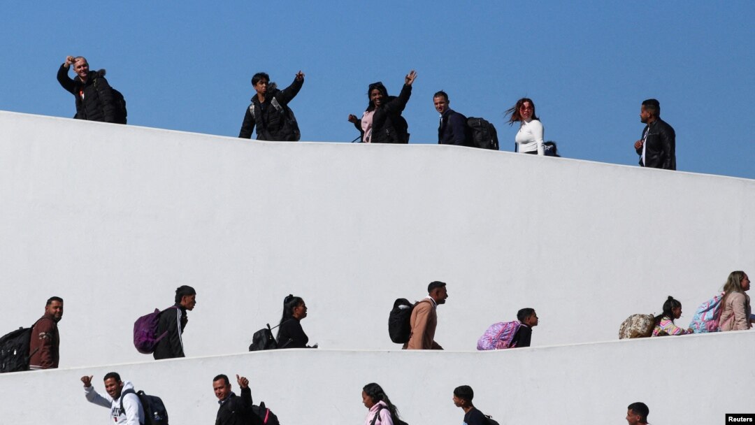 FILE - Migrants who requested an appointment for asylum in the United States walk towards El Chaparral, at the border between Mexico and the U.S, in Tijuana, Mexico Nov. 4, 2024. 